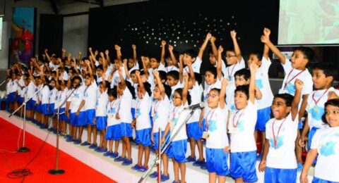 Students performing a coordinated group activity on stage during a school event